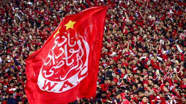 Supporters hold a giant Wydad's flag as they attend the CAF Champions league's match between Wydad Casablanca and Zamalek at the Mohammed V Stadium, in Casablanca, on February 26, 2022, after the reopening of the football fields in Morocco. (Photo by AFP)